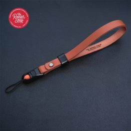 TRS - Premium leather wrist camera strap in saddle tan color, featuring a Beans quick-release buckle